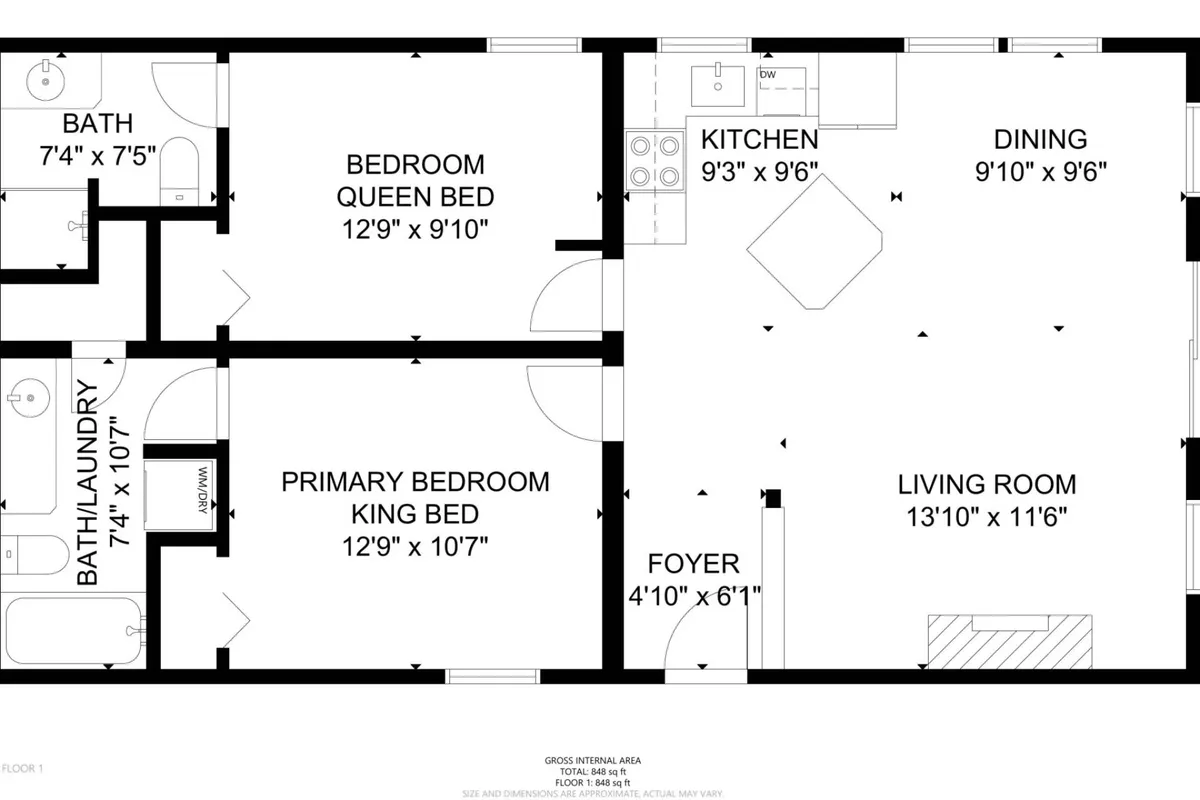 A wide-angle view of the open-plan interior showing the living room with a sofa, a glimpse of the primary bedroom, and adjacent dining and kitchen areas. The space is comfortable and inviting, hinting at the sleeper sofa for extra guests.